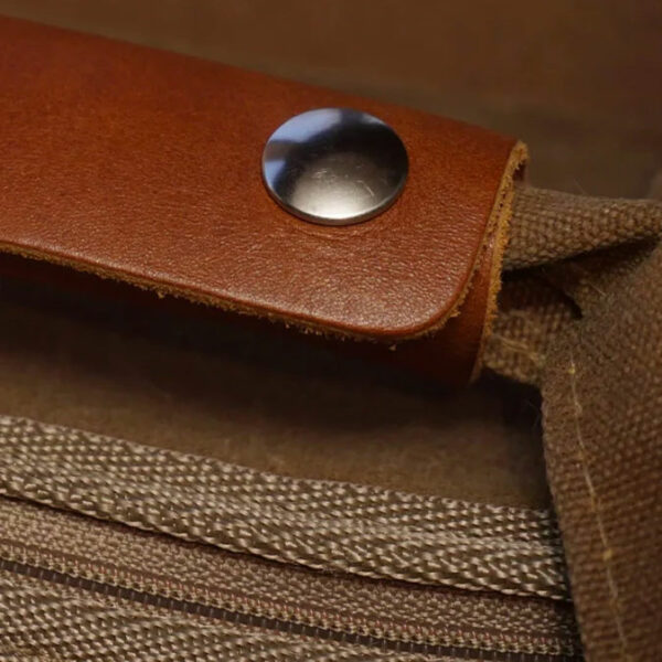 Close-up of a brown leather strap secured with a silver snap button