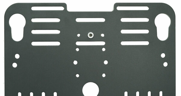 A dark metal plate with various cutouts and holes