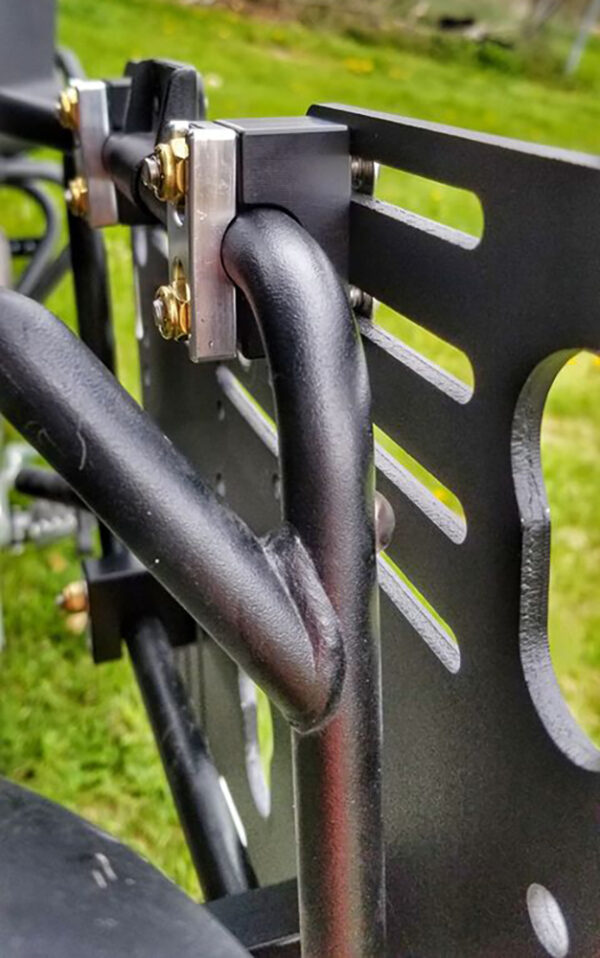 Close-up of a black metal bracket with bolts and a curved pipe