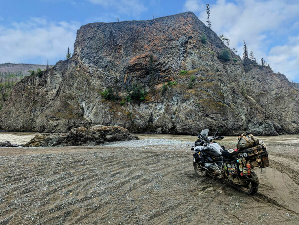 A heavily packed motorcycle parked on a sandy beach