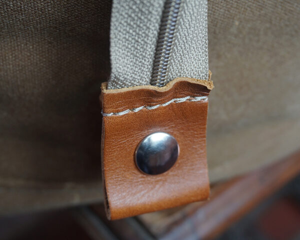 Close-up of a brown leather strap with a metal snap