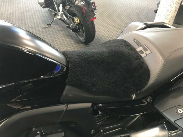 A black motorcycle seat cover made of plush material