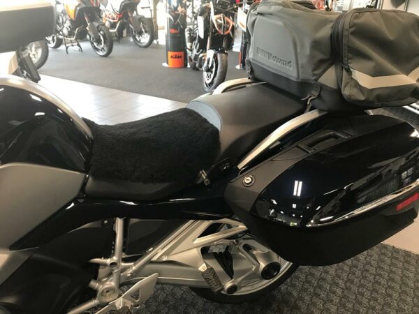 Close-up of a motorcycle seat covered with a black sheepskin