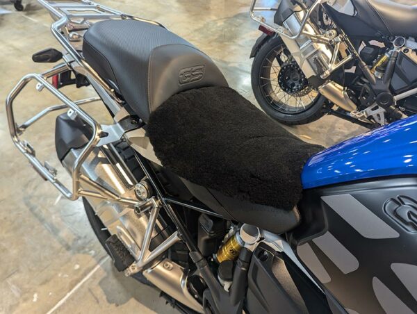A motorcycle seat covered with a black fur seat pad