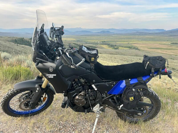 A black and blue Yamaha Tenere 700 motorcycle parked on a hillside