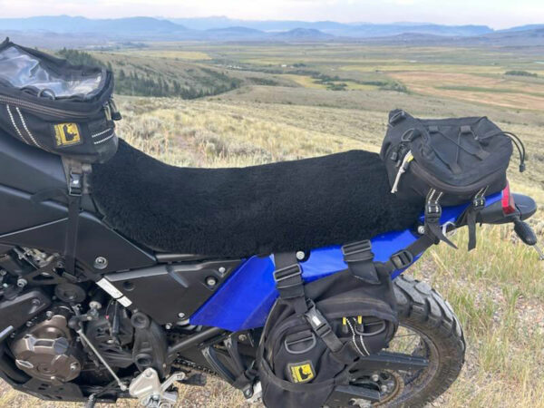 A motorcycle with a plush seat cover and saddlebags
